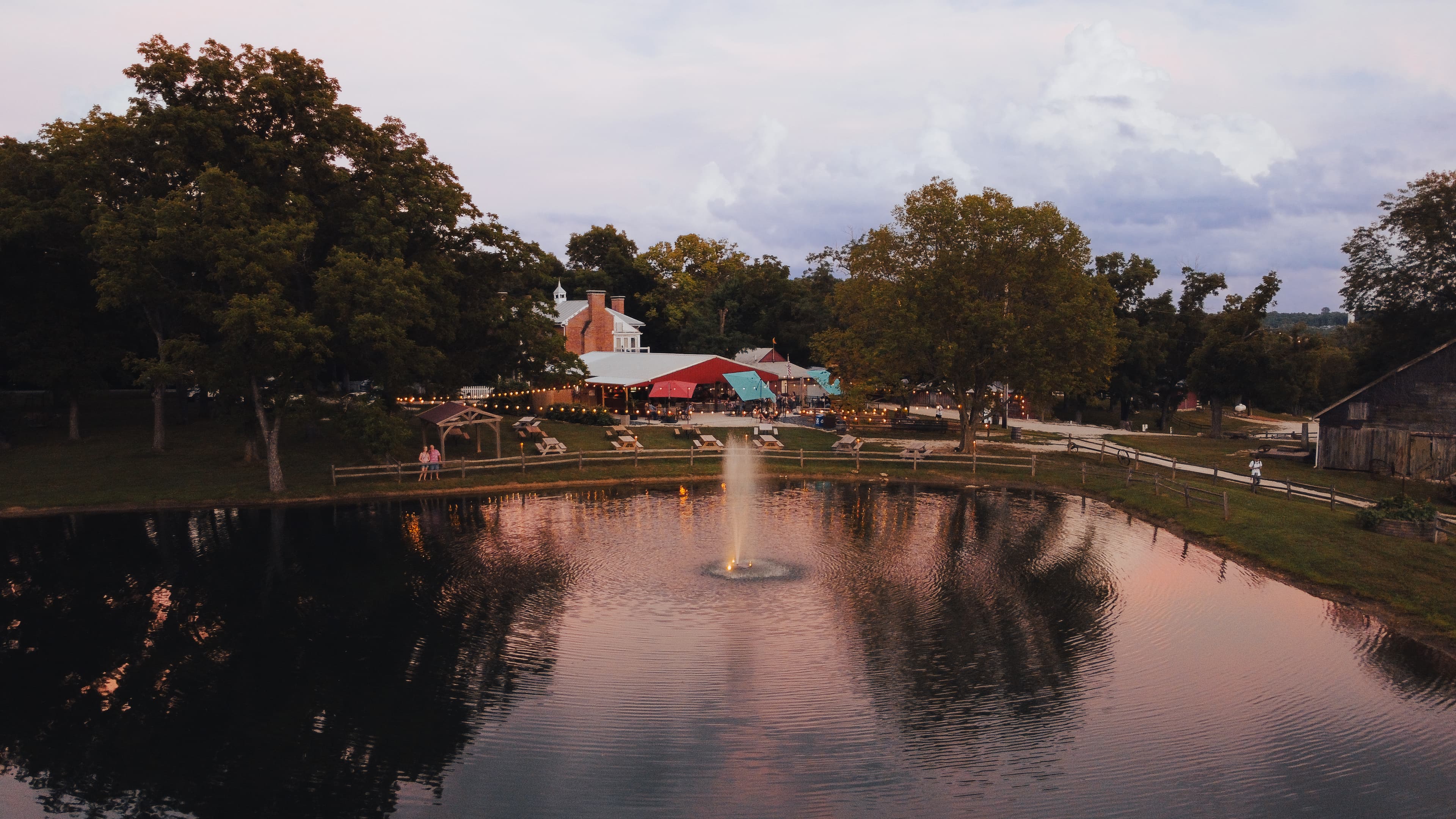 Aerial view of The Pavilion at Iron Turbine beside the pond at dusk.